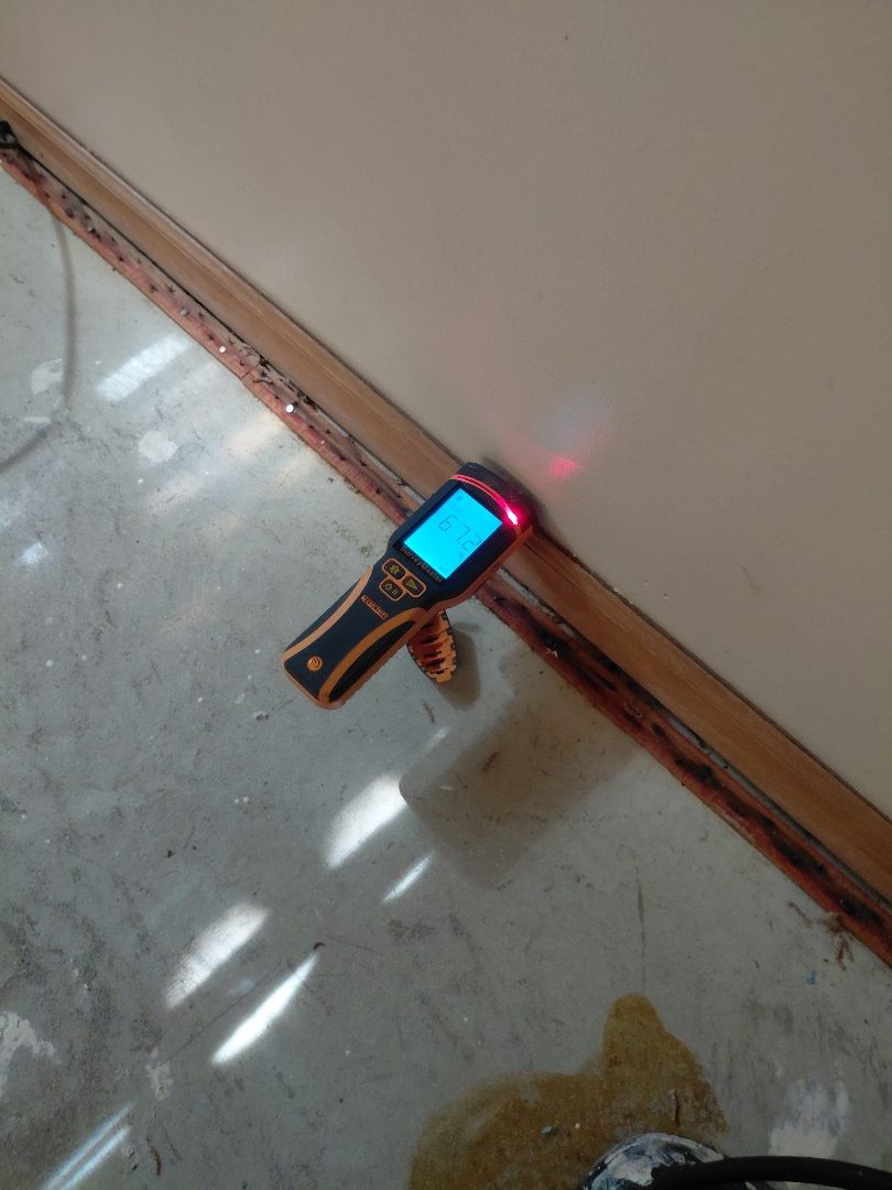 Arrival — meter check where wet floor meets the wall